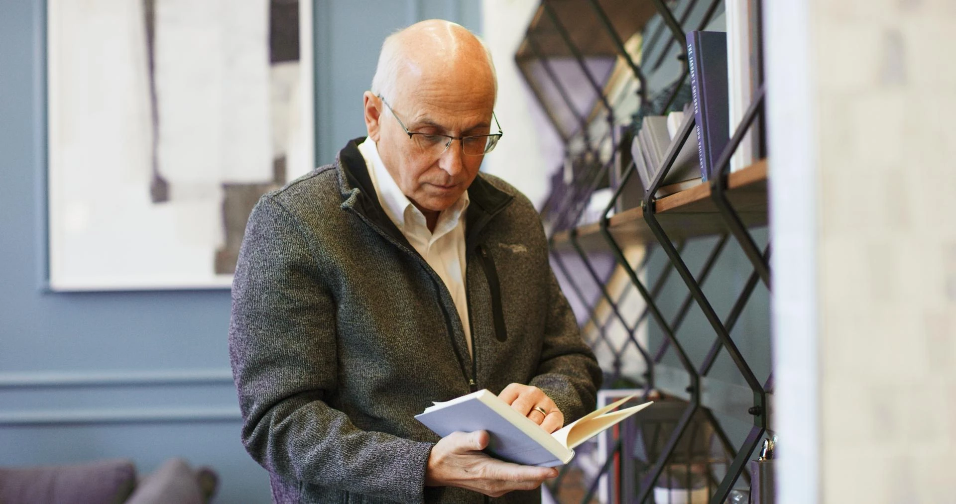 A senior man looking through a book in his senior housing
